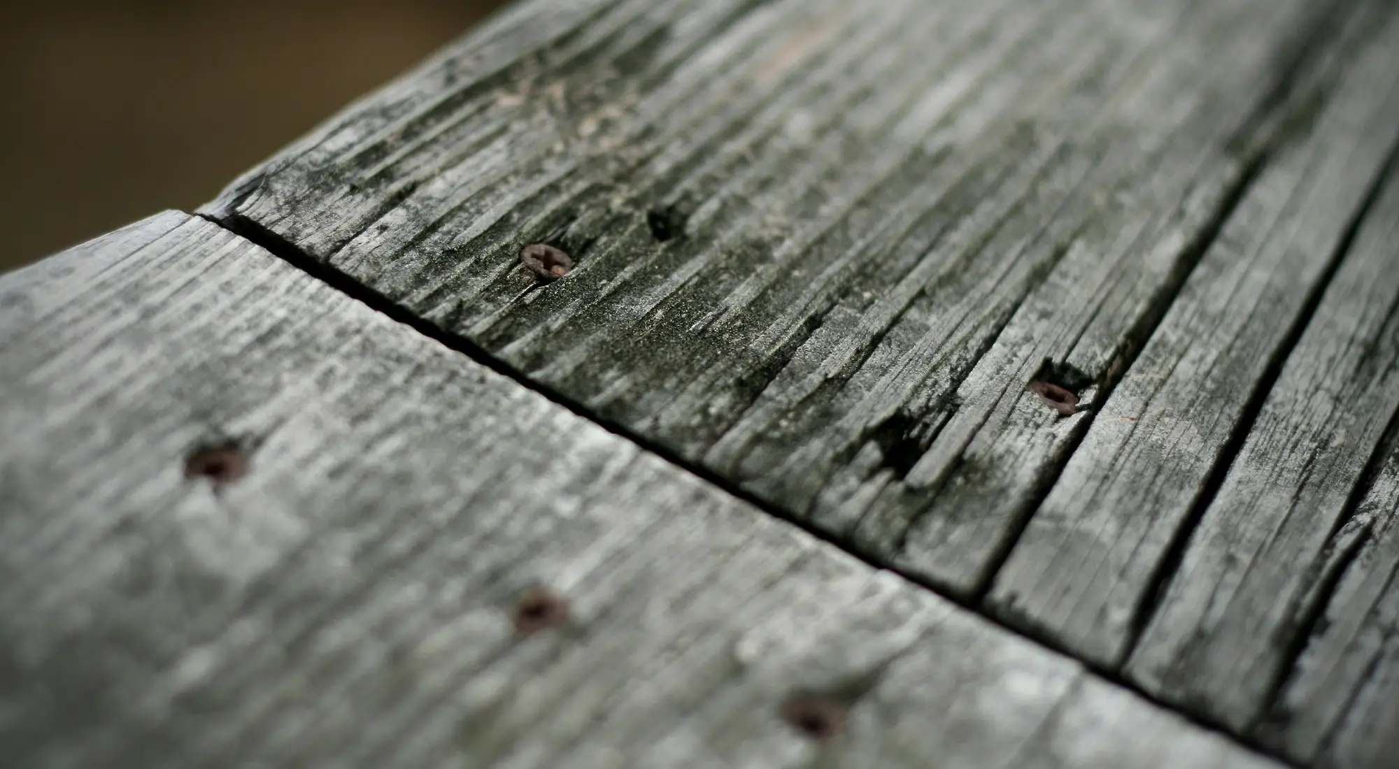 Détail de lames en bois extérieur marquées par le temps et de leurs fixations