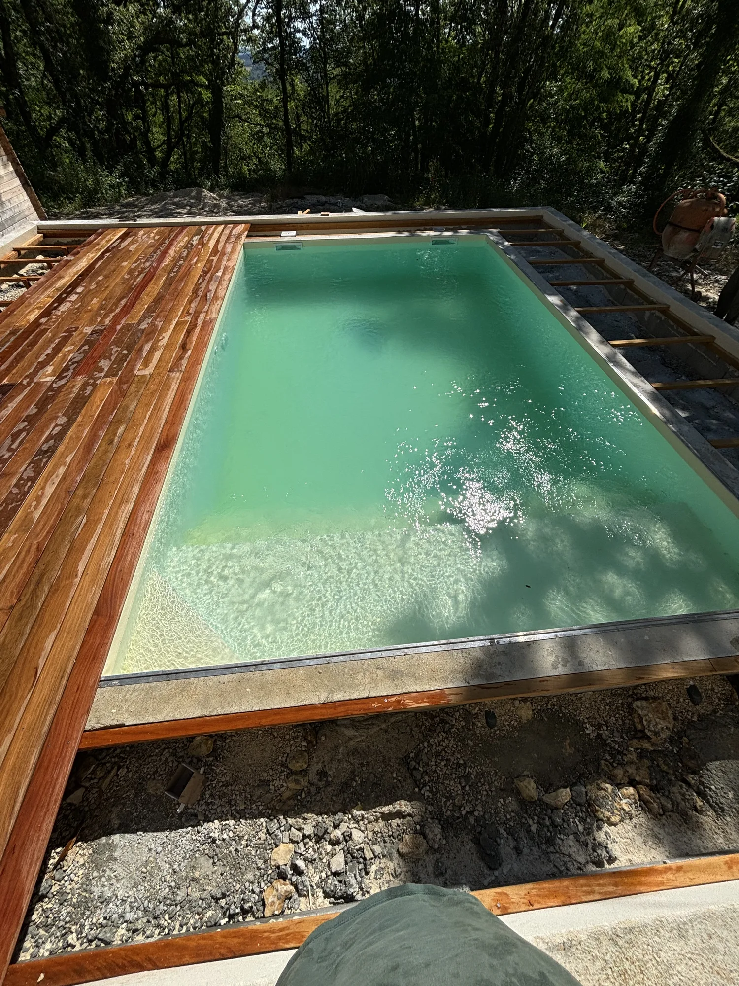 Vue plongeante sur une piscine rectangulaire et la terrasse en cumaru en cours de pose à Arcachon à Arcachon