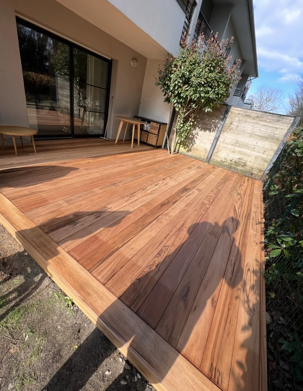 Terrasse en Muiracatiara aux tons brun rouge le long d’une maison à Audenge