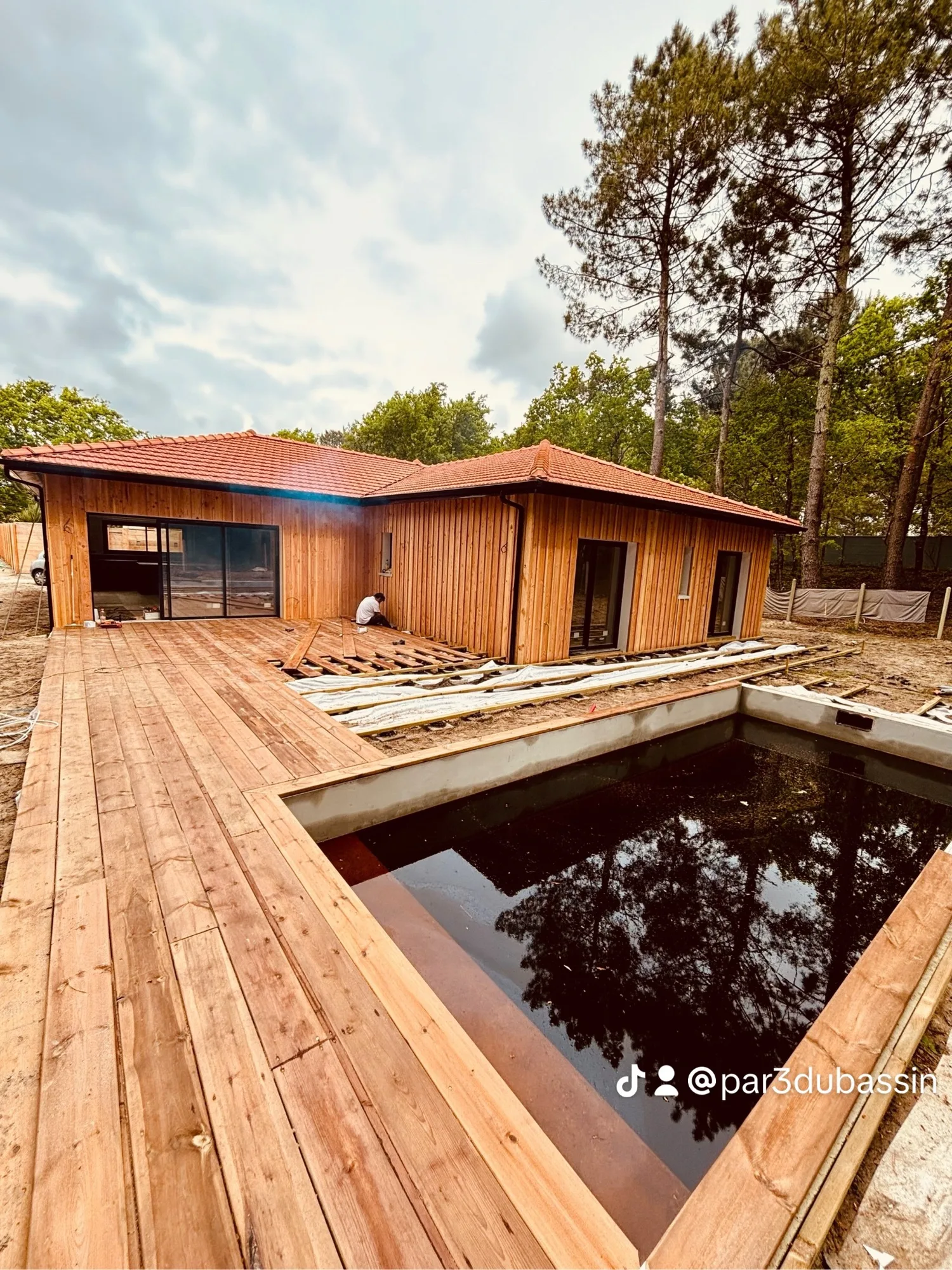 Grande terrasse en pin autour d’une piscine avec bardage Douglas sur la maison à La Teste-de-Buch