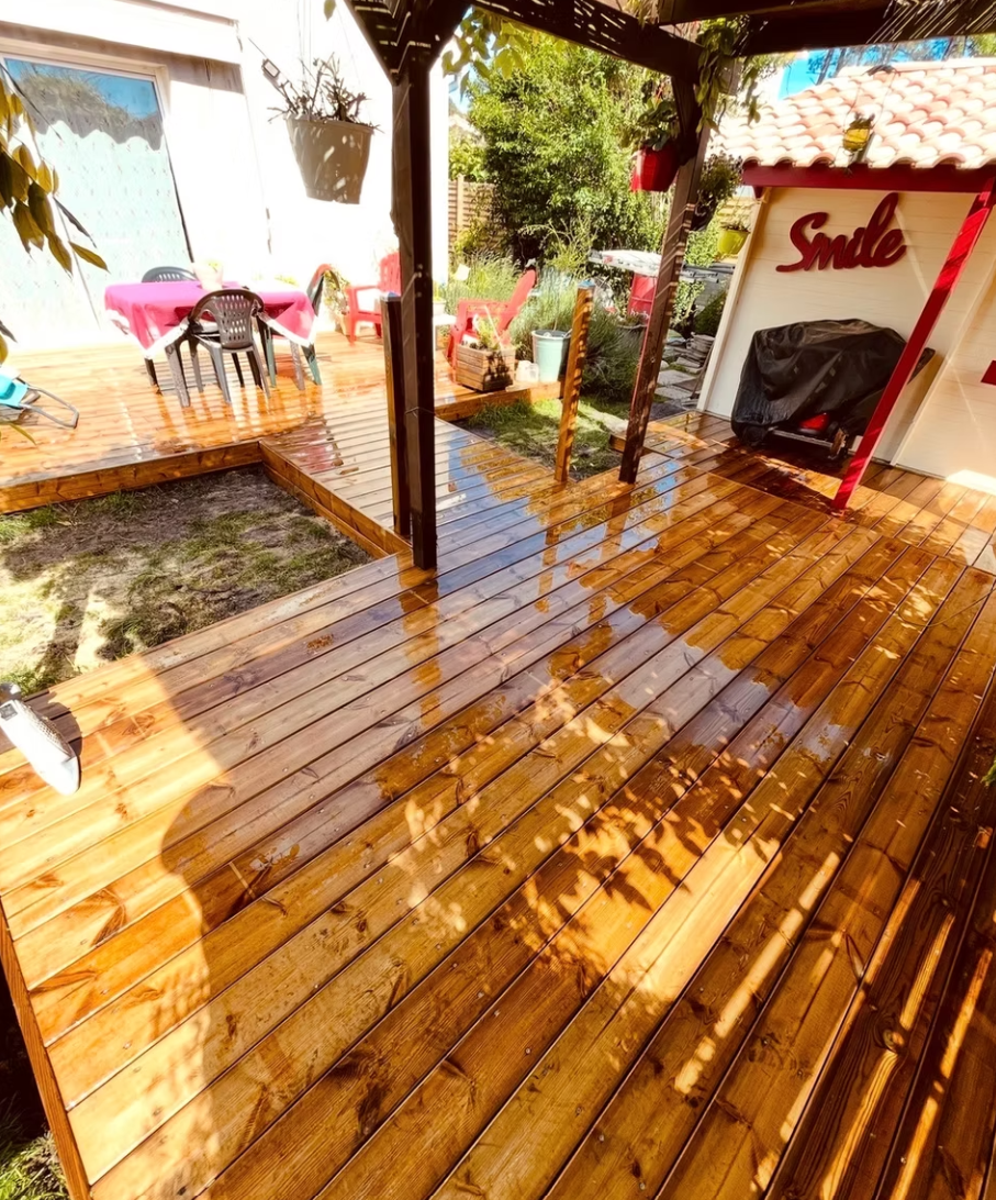 Terrasse en bois aux tonalités chaudes dans un patio